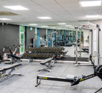 Modern hotel gym with sleek equipment, weights, and cycling machines, ideal for fitness-focused guests.