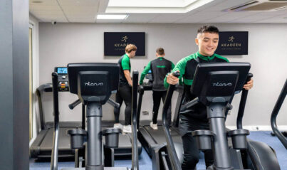 Guests enjoying modern gym with treadmills and flat-screen TV at Keaden Hotel, perfect for fitness enthusiasts.